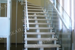 Лестница на металлическом каркасе с деревянными ступенями и стеклянными ограждениями изготовлена и установлена для частного загородного дома